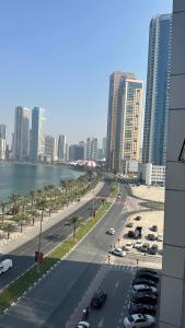 una calle de la ciudad con coches aparcados en un estacionamiento en sharja p702, en Sharjah