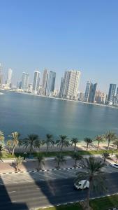 a large body of water with palm trees and buildings at sharja p702 in Sharjah