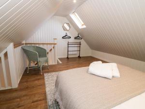 a attic room with a bed and a chair at The Annex in Pershore
