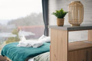 Habitación con cama con toallas y maceta. en Duna Lodge - Luxury Apartment, en Dunaszentmiklós