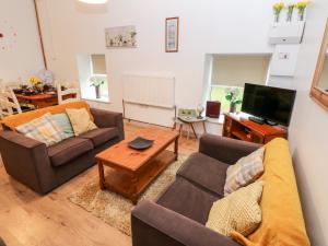 a living room with two couches and a tv at Barn 2 in Swansea