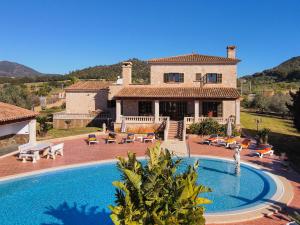 a villa with a swimming pool in front of a house at Finca Aguilas in S'Horta