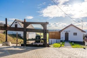 a house with a wooden gate in front of a building at Duna Lodge - Luxury Apartment in Dunaszentmiklós