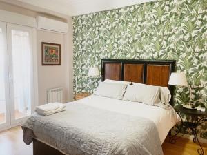 1 dormitorio con 1 cama con papel pintado verde y blanco en Un hogar en el centro - La Casa de Ion Parking gratuito, en Zaragoza