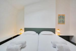 2 Betten in einem weißen Zimmer mit 2 Lampen in der Unterkunft Le Grand Amerval in Nancy