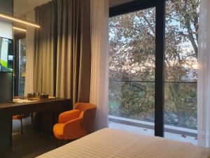 a bedroom with a bed and a desk and a window at Avenue21 in Zagreb