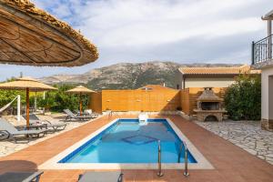 a swimming pool with a mountain in the background at "Villa ANDREAS" in Ayia Evfimia