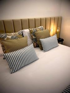 een groot bed met verschillende kussens erop bij BLUE ANCORA HOTEL in Vila Praia de Âncora