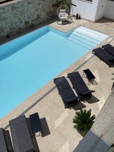 a swimming pool with chairs and a group at BLUE ANCORA HOTEL in Vila Praia de Âncora