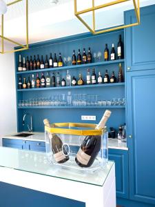 uma cozinha azul com garrafas de vinho nas prateleiras em BLUE ANCORA HOTEL em Vila Praia de Âncora