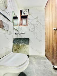 uma casa de banho com um WC branco e um lavatório. em Glace Residency By Excellent Hospitality em Nova Deli