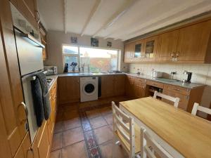 a kitchen with a table and a sink and a dishwasher at Geneva Cottage (Twin Room) in Darlington