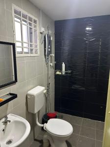 a bathroom with a toilet and a sink and a phone at Homestay Triang in Kampong Kerayong