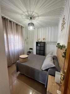 una camera da letto con un grande letto e un soffitto bianco di PISO Guadix MB a Guadix