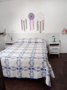 a bedroom with a bed with a blue and white quilt at Refugio de paz in Jaureguiberry