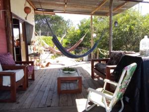 - une terrasse couverte avec un hamac, une table et des chaises dans l'établissement Refugio de paz, à Jaureguiberry