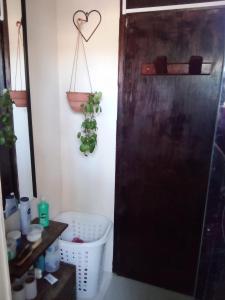 a bathroom with a black door and a plant at Refugio de paz in Jaureguiberry