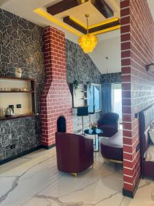 a living room with a brick wall at kollanoor guest house in Madikeri