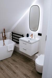 bagno bianco con lavandino e specchio di THE VIEW - WILLA z basenem a Iława