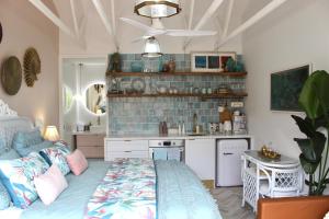 a bedroom with a large bed and a kitchen at Sandpiper Studio in Scarborough
