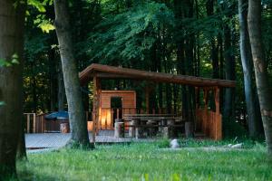 a wooden pavilion with a picnic table in the woods at THE VIEW - WILLA z basenem in Iława