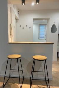 two stools in front of a counter with a mirror at Appartement Cosy Beauvais in Beauvais