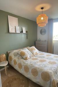 a bedroom with a bed and a pendant light at Appartement Cosy Beauvais in Beauvais