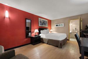 a hotel room with a bed and a red wall at Quality Inn Wayne - Fairfield Area in Wayne +47 photos