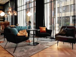 ビーレフェルトにあるibis Styles Bielefeld Cityの椅子とテーブル、大きな窓が備わる客室です。