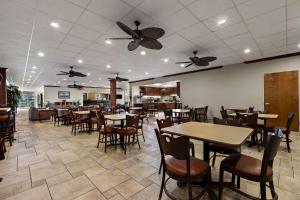 un restaurante con mesas, sillas y ventiladores de techo en Quality Inn Wayne - Fairfield Area, en Wayne