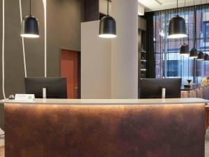 a reception counter in a lobby with chairs at ibis Styles Bielefeld City in Bielefeld