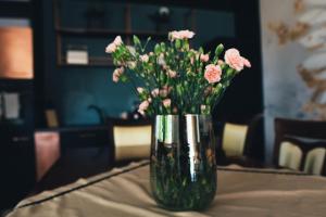 un vaso pieno di fiori rosa su un tavolo di THE VIEW - WILLA z basenem a Iława
