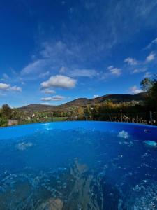 a pool of blue water with mountains in the background at Apartament Wrzosowisko in Brenna