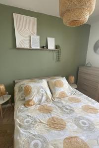 a bedroom with a bed with a comforter and pillows at Appartement Cosy Beauvais in Beauvais