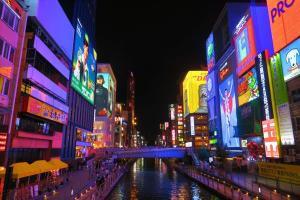 um rio numa cidade à noite com sinais de néon em Hotel Boti Boti em Osaka