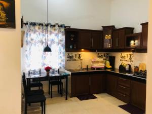 a kitchen with wooden cabinets and a table and a window at Villa D40 in Weligama