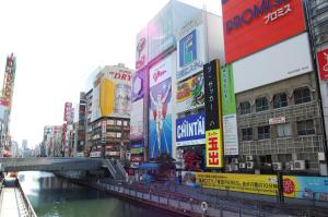 um rio numa cidade com muitos sinais em edifícios em Hotel Boti Boti em Osaka