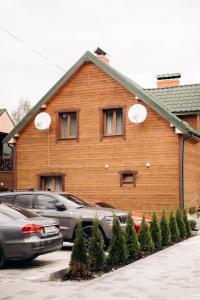 una casa de madera con coches aparcados frente a ella en Готель Bliznuky, en Vorokhta