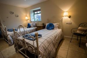 two beds in a bedroom with blue pillows at The Forge in Selby