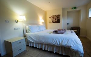 um quarto com uma cama branca com uma cómoda e uma cama sidx sidx em The Forge em Selby