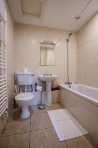 een badkamer met een toilet, een wastafel en een bad bij The Forge in Selby