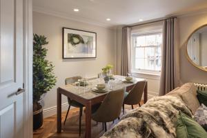 a dining room with a table and a couch at Darley House by Viridian Apartments in London