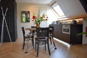 een keuken en eetkamer met een tafel en stoelen bij Stijlvol appartement 'Moto' in centrum Franeker. in Franeker