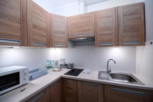 a kitchen with wooden cabinets and a sink and a microwave at Jesionowa Standard Apartment in Wrocław