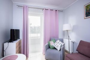 a living room with a couch and a tv at Jesionowa Standard Apartment in Wrocław