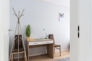a desk with a chair next to a white wall at Jesionowa Standard Apartment in Wrocław