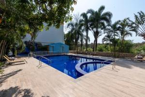 a large swimming pool with blue water in a yard at Saavaj Resort in Sasan Gir