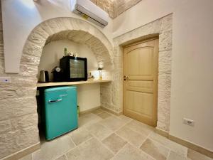 a kitchen with a blue refrigerator in a room with a door at Trulli Contento - Rooms & Apartments in Alberobello