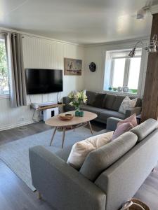a living room with a couch and a table at Koselig hus nært havet i Lofoten, Kabelvåg in Kabelvåg
