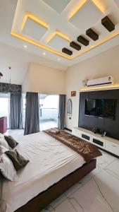 1 dormitorio grande con 1 cama grande y TV de pantalla plana en kollanoor guest house en Madikeri